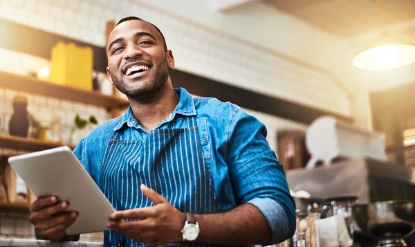 Laugh, tablet and waiter with man in cafe for online, entrepreneurship and startup. Retail, technology and food industry with small business owner in restaurant for barista, store and coffee shop.