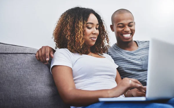 相互に接続するよりも良いものは何もありません 自宅でリラックスしながらノートパソコンを使っている若いカップルが — ストック写真