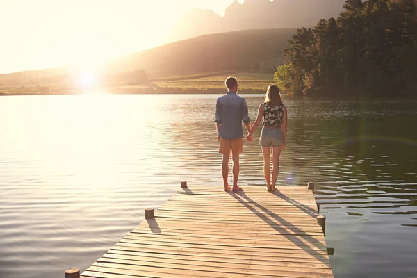 湖畔の夕日 夕暮れ時にドックに立っている愛情のある若いカップルのレビューショット — ストック写真