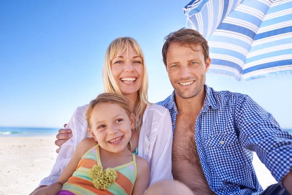 私たちの別荘は海岸のすぐそばです 幸せな若い家族が一緒にビーチの傘の下に座って — ストック写真