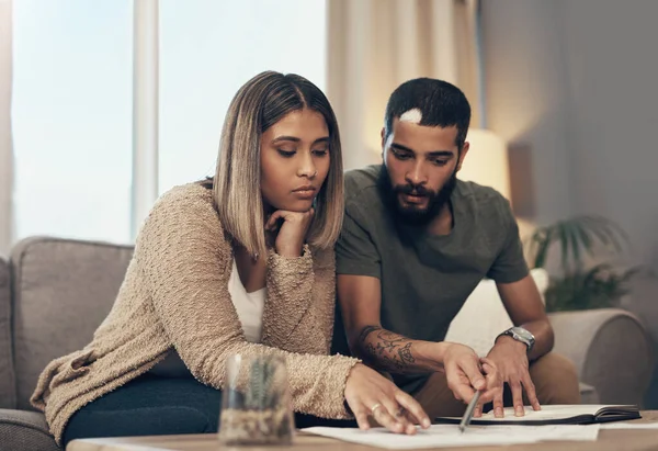 Time to take back control of your finances. a young couple going over paperwork at home