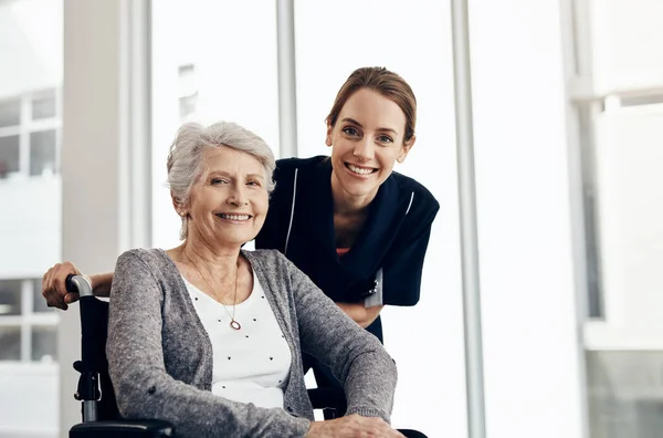 stock image She takes good care of her patients. a female nurse caring for a senior woman in a wheelchair