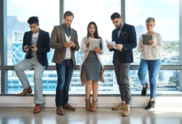 stock image Handling business the best way we know how. Full length shot of a diverse group of businesspeople using wireless technology in an office