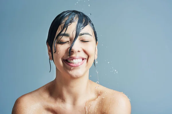 水のスプラッシュや女性の顔は 掃除やグルーミングのための青の背景にシャワー ヘアドライヤー ボディケアとスタジオでのクレンジングのためのスキンケア バスルームと幸せな女性の人 — ストック写真