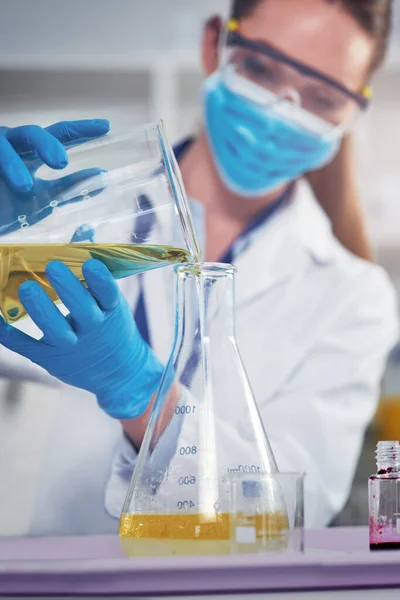 stock image I hope nothing goes wrong. an unrecognizable female scientists wearing a protective face mask while mixing chemicals together inside of a laboratory