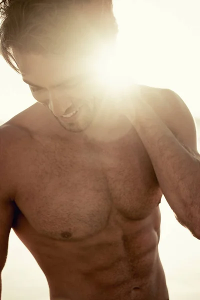 日光浴をする 夕暮れ時に浜に立っているハンサムな男が見下ろしている — ストック写真