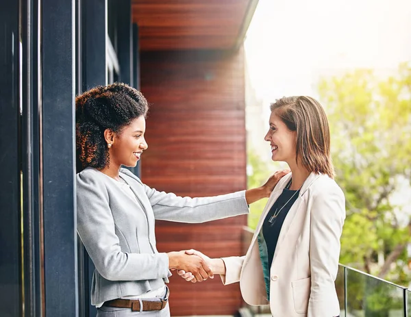 stock image Im so glad to be working alongside you. two businesswomen shaking hands outside an office