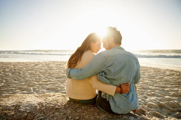 親密さの瞬間を大切にする ビーチに親密な方法で座っている愛する若いカップルのレビューショット — ストック写真