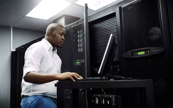 Engineer, black man or coding on laptop in server room for big data, network glitch or digital website. Code, IT support or technician typing on computer testing, programming or software development.