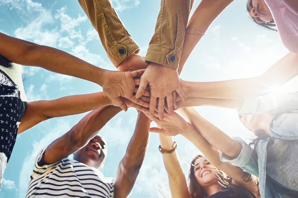 stock image Team building, hands and low angle of business people in solidarity or partnership on blue sky background. Teamwork, agreement and below hand collaboration for motivation, help or friends celebration.