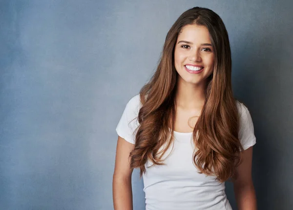 stock image She has the most beautiful smile. Studio shot of an attractive young woman posing against a gray background