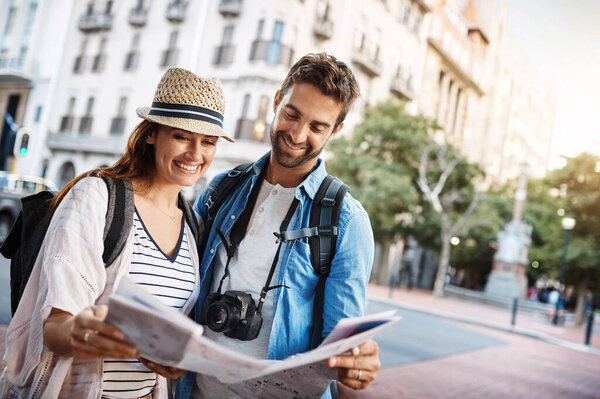 Couple, tourist and a map in a city for travel on a street for direction or location search. Man and woman together with paper for navigation outdoor on urban road for adventure, journey or vacation.
