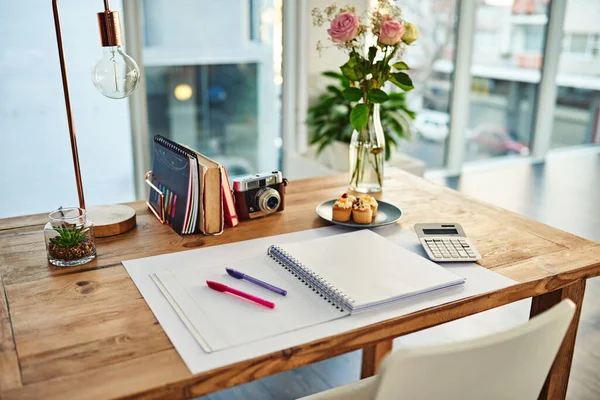 Remote work, book and desk in creative workplace with paper for writing, planning and idea inspiration. Notebook, space and workspace table for freelance business in home office room for creativity.