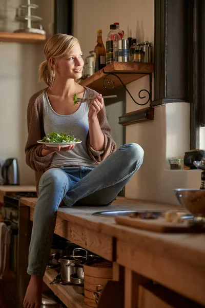 她总是以最新鲜的配料开始新的一天 一个年轻女子在乡村厨房里吃了一碗绿叶绿叶的照片 — 图库照片