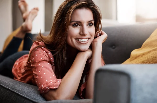 stock image Sure feels good to take a break. an attractive young woman relaxing on the sofa at home