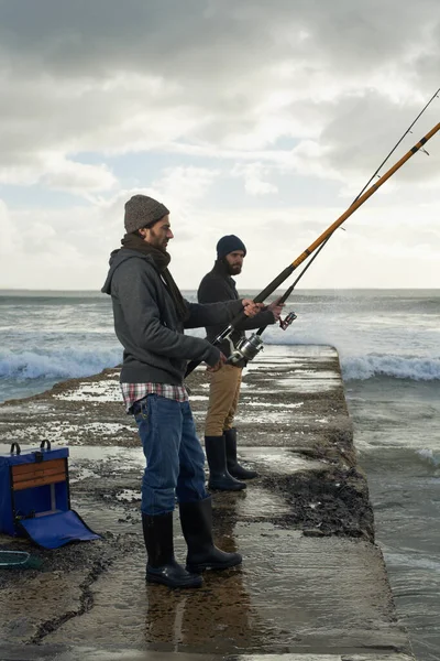 人間のゲームを釣る 早朝2人の若い男が海で釣りをしている — ストック写真