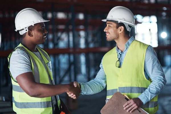 Lets go team. two young contractors standing in the warehouse together and shaking hands