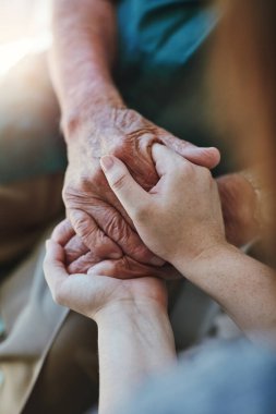 Üst düzey erkek, kadın ve birlikte yakın çekim yaparken özen ve empati ile destek için el ele tutuşmak. Umut, güven ve nezaket için veya hayat sigortası ve sağlık için yaşlı erkek ve kişinin eli.