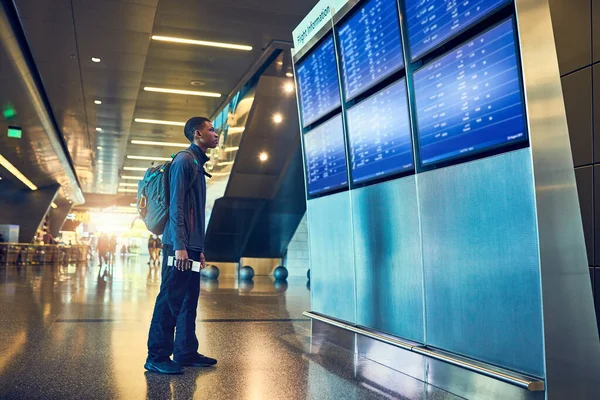 Много Перелетов Молодой Человек Смотрит Табло Аэропорту — стоковое фото