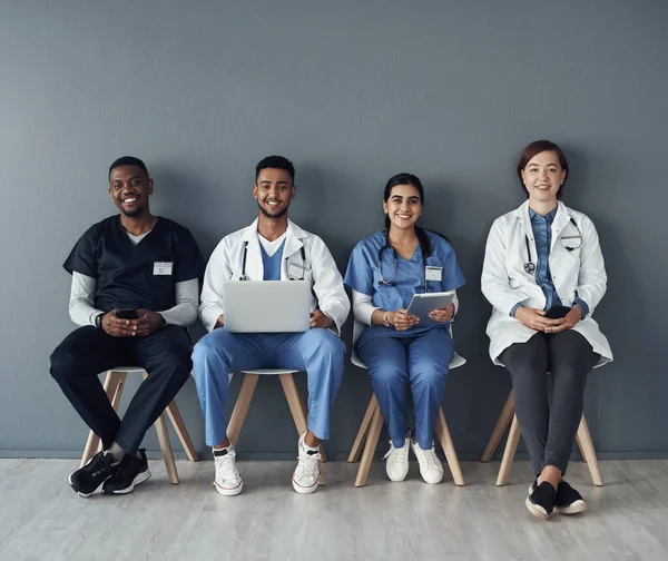 stock image The toughest and responsible job is to be a doctor. a group of doctors sitting against a grey background at work