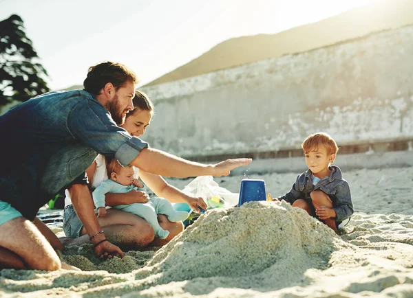 砂の城の助け 結合とビーチでの親と子供 愛とサポート 海と海と家族で幸せと笑顔で太陽の下で遊んでいる子供たちと一緒に赤ちゃん お母さんとお父さん — ストック写真