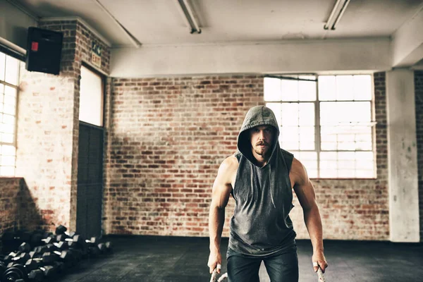 stock image Hooded and fit. a hooded and determined young man making use of ropes to workout in the gym