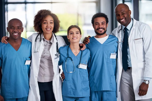 他们是来救你的白天 一群手挽手站在医院里的快乐的医生的画像 — 图库照片