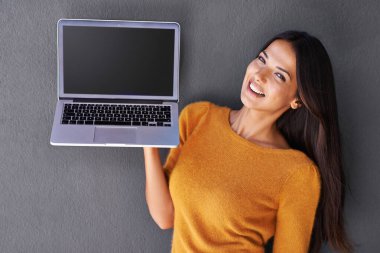 Bunun hakkında ne düşünüyorsun? Elinde boş bir ekranla dizüstü bilgisayar tutan çekici genç bir kadının portresi.