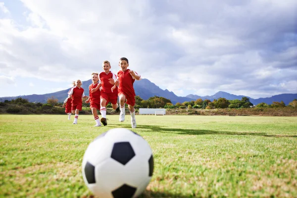 与儿童一起跑步 健身和运动 在运动场上踢足球 进行训练 比赛和团队合作的模拟 与足球运动员在球场上为目标 精力和孩子们的行动 — 图库照片