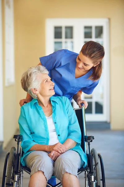高齢者のサポートを支援する病院の診療所で車椅子の話 看護師や幸せな高齢者の女性 障害のある高齢者と話す信頼 笑顔または医療介護者 — ストック写真