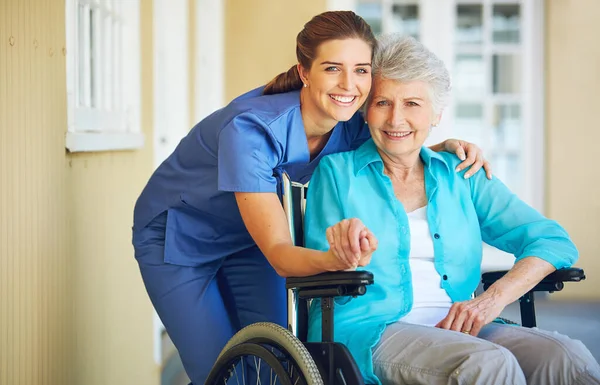 高齢者の支援を支援する病院の車椅子の看護師 抱擁または高齢者の肖像画 手をつなぐこと 笑顔を笑顔にすること 介護者が高齢者の女性と笑顔になること — ストック写真