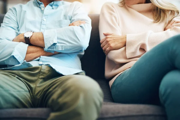 Divorce, angry and couple fight arms crossed due to family law problem in a marriage with conflict in a home lounge. Anger, living room and partner or people frustrated, depressed and mad on a sofa.