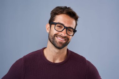 The perfect frames to enhance his handsomeness. Studio shot of a handsome and happy young man posing against a gray background