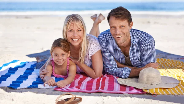 彼らはビーチが大好きです ビーチでリラックスした幸せな若い家族の肖像画 — ストック写真
