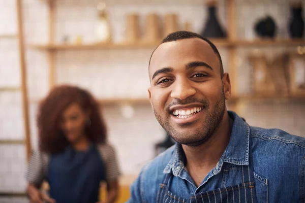 stock image Would you like your java strong. a handsome young businessman standing in his cafe while a barista works behind him