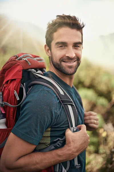 stock image Hiking, fitness and portrait of man on mountain for peace, adventure and travel journey. Backpacking, summer and workout with male hiker trekking in nature path for training, freedom and explore.