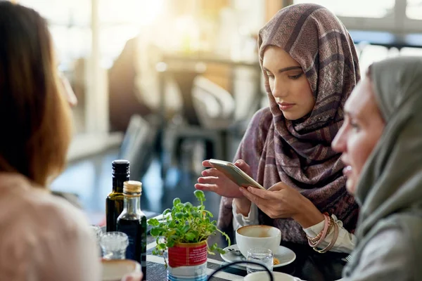 电话和穆斯林妇女在咖啡馆里 结伴聊天 咖啡店 手机和伊斯兰女孩 团体或人们在餐馆里为社交聚会放松 交谈和讨论 — 图库照片