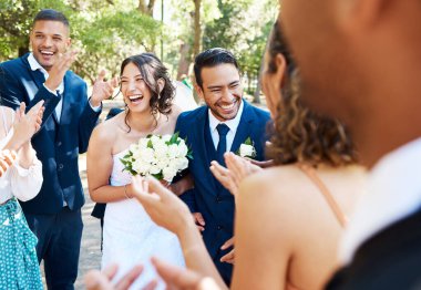 Mutlu gelin ve damat düğün töreninden sonra gülüyor ve neşeli görünüyorlar ve düğünlerinde arkadaşlarıyla ve aileleriyle kutlamaya hazırlar..