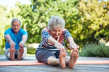 Doğa, yoga esneme ve yaşlı çiftler parkın zemininde egzersiz, antrenman ya da sağlık hizmetlerine başlarlar. Sağlık, özgürlük ve yaşlı evlilik insanları, pilates yapan erkek ya da kadın..