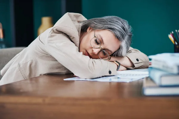 Let me just close my eyes for five minutes. an attractive mature businesswoman asleep at her desk in her home office