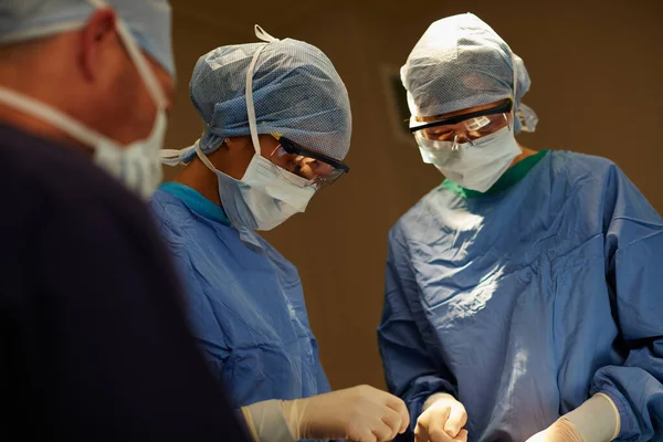 熟练的拯救生命 在手术室里进行外科手术的一组外科医生 — 图库照片