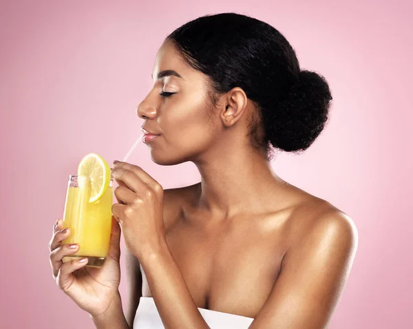女性の顔 スタジオでオレンジジュースやドリンク 健康的なスキンケアのためのピンクの背景とデトックス 栄養の利点 自然の美しさや健康のためのアフリカモデル 柑橘類スムージーとビタミンCの果物 — ストック写真