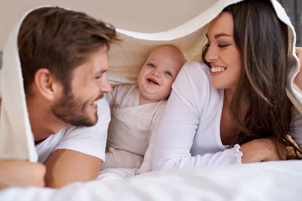 快乐的母亲 父亲和婴儿 床上铺着毛毯 关怀和美好的时光在一起 家人和顽皮的新生儿在卧室里悠闲自在地躺在床上 带着床上用品 带着微笑和亲密地呆在家里 — 图库照片
