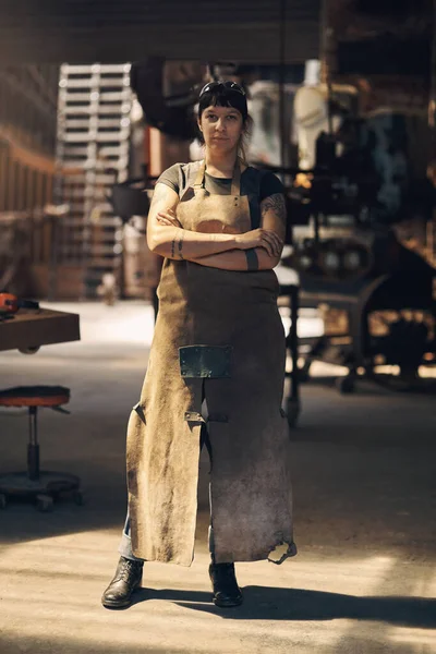 stock image Blacksmith, workshop and portrait of woman with crossed arms for industry, manufacturing and welding. Industrial factory, warehouse and female person for steel, iron and metal production in foundry.