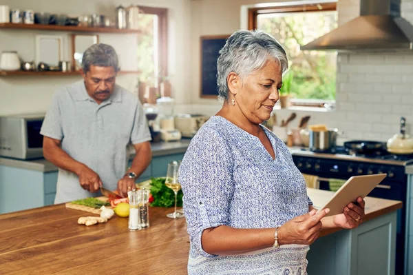 老太婆和男人在厨房里 平板电脑和烹调健康食品一起在家里与营养 数码菜谱 与老夫老妻共进午餐 幸福安康的退休生活 — 图库照片