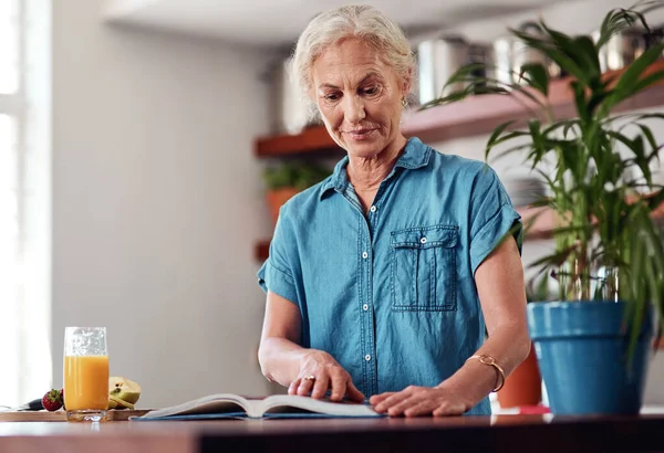 Looks Goodie Attractive Senior Woman Reading Recipe Book While Preparing — Stock Photo, Image