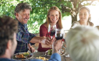 Aile, grup ve şarap kadehleri kutlama için masada tost, yemek ve öğle yemeğinde arkadaşlar. Erkekler, kadınlar ve kutlamak için birlikte gülümseyin. Alkol, bardak ve destekle. Parti, akşam yemeği ya da evde..