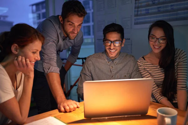 stock image Teamwork, night and a business group on a laptop, working in the boardroom for planning, strategy or innovation. Meeting, collaboration and overtime with a team of employees at work in the evening.