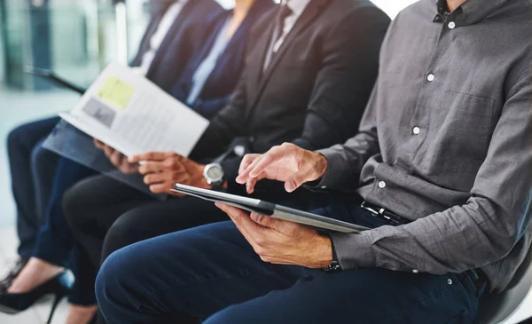 stock image Browsing some interview tips online. a group of unrecognizable businesspeople sitting in line for an interview in a modern office