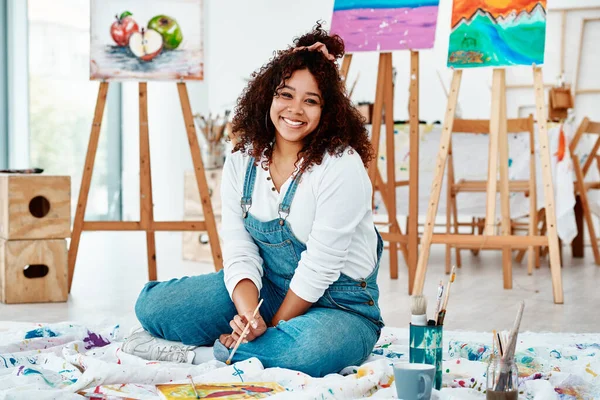 stock image My smile is my signature. Full length portrait of an attractive young artist sitting alone and painting during an art class in the studio